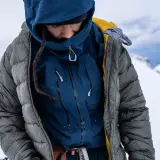 Person in Daunenjacke im Schnee. Tipps zur Daunenjacke Reinigung oder selber waschen.