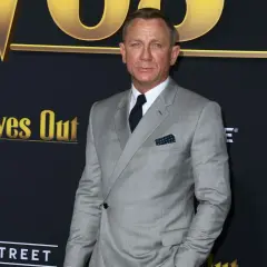 Daniel Craig trägt einen eleganten hellgrauen Anzug mit einem dunkelblauen Einstecktuch.