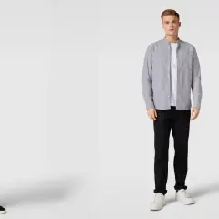 Zwei Männer präsentieren, wie man ein graues Hemd kombinieren kann: lässig mit schwarzer Jeans und Sneakern.