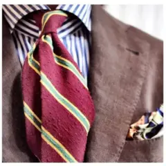 Drei Herren-Outfits mit Krawatten: eine rote Krawatte, eine gestreifte Krawatte und eine grüne Krawatte mit Muster. Perfekt, um zu lernen, wie man eine Krawatte binden kann.