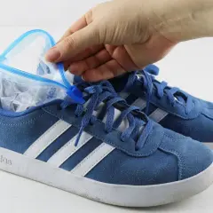 Blauer Sneaker wird mit einem gefüllten Gefrierbeutel geweitet. So kann man Schuhe weiten.