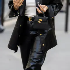 Schwarze Lederhose mit passendem Blazer und kleiner Handtasche. Die Frage "welche schuhe zur schwarzen hose damen" wird hier stilvoll beantwortet: schlichte, elegante Schuhe.