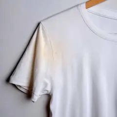 Weiße T-Shirt mit gelblichen, unbekannten Flecken nach dem Waschen unter dem Arm.
