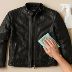 Schwarze lederjacke reinigen mit einem Tuch und Sprühflasche.