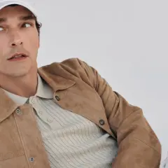 Mann mit weißer Kappe trägt einen braunen Wildleder-Anzug mit Poloshirt.