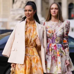 Zwei Frauen in blumigen Kleidern und eleganten Jacken. Perfekt, wenn man überlegt, was zieht man zur Hochzeit an.