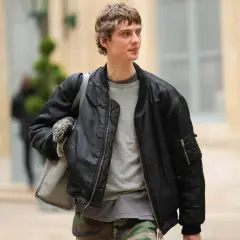 Ein Mann trägt eine schwarze Bomberjacke, die er lässig mit einem grauen Pullover und Camouflage-Hose kombiniert. Perfekt für den lässigen Herren-Look.