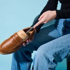 Braune Loafer werden mit einem Schuhspanner geweitet.