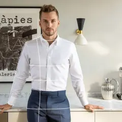 Mann mit weißem Hemd und blauer Hose, bereit, die Ärmel hochzukrempeln. Im Hintergrund ein Bild und eine Kaffeemaschine.