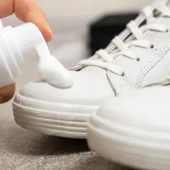 Schaum wird auf weiße Sneaker aufgetragen, um helle Schuhe reinigen.