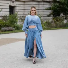Frau in einem langen Jeanskleid mit Cut-outs und Puffärmeln, dazu schwarze Riemchensandalen. Die perfekte Inspiration, welche Schuhe zum Jeanskleid passen.