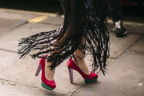 Bunte High Heels Arten mit Plateau und Fransenrock.