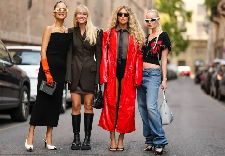 Vier Frauen präsentieren unterschiedliche Dresscodes: von elegantem Schwarz über lässige Jeans bis hin zu auffälligem Rot.