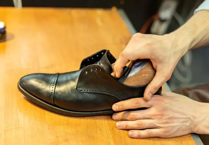 Schuhe weiten: Leder wird mit einem Leisten in Form gebracht, um den perfekten Sitz zu erzielen.