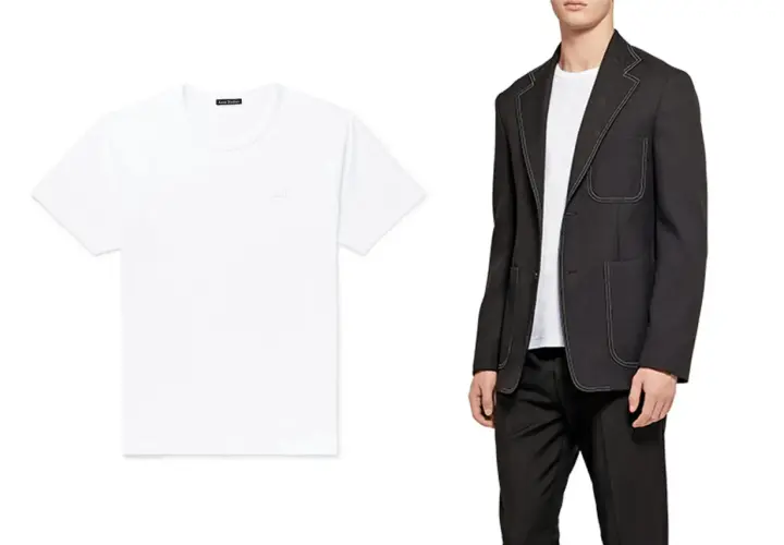 Ein weißes hemd ohne kragen von Acne Studios liegt neben einem Mann im schwarzen Anzug.