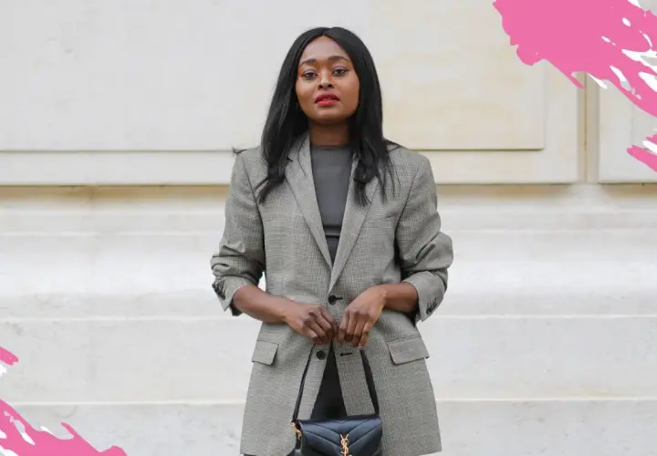 Eine Frau in einem karierten Blazer und dunklem Oberteil verkörpert smart business casual. Sie trägt eine schwarze Handtasche.
