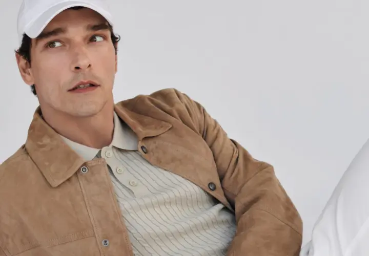 Mann mit weißer Kappe trägt einen braunen Wildleder-Anzug mit Poloshirt.