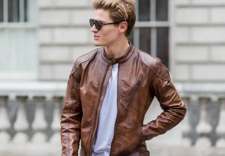 Mann mit brauner Wildlederjacke, die er reinigen möchte. Sonnenbrille und weißes T-Shirt.