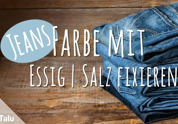 Neue Jeans Farbe mit Essig fixieren: Ein Stapel Jeans auf Holz.