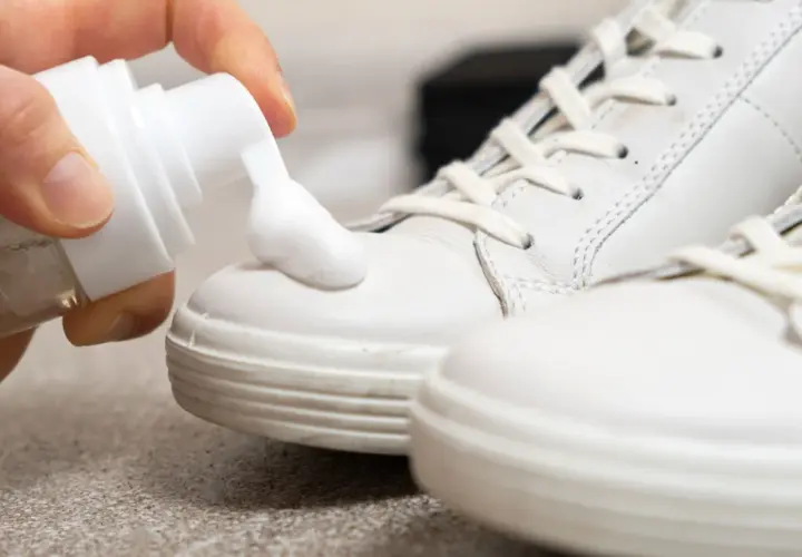 Schaum wird auf weiße Sneaker aufgetragen, um helle Schuhe reinigen.