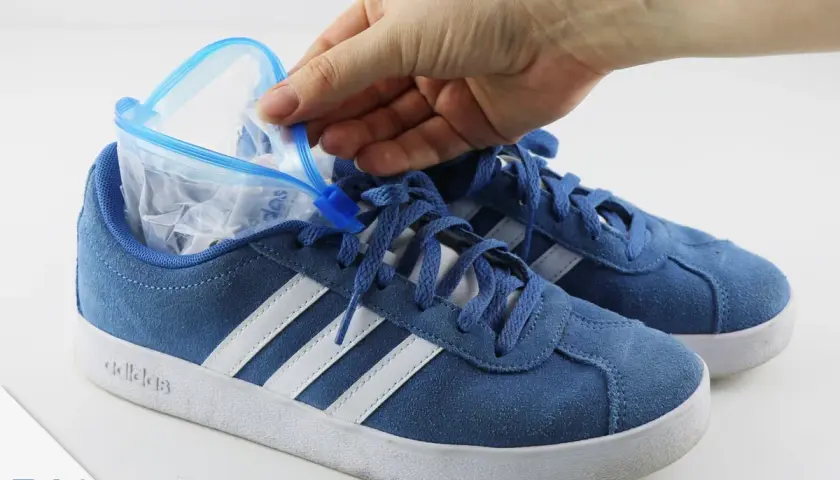 Blauer Sneaker wird mit einem gefüllten Gefrierbeutel geweitet. So kann man Schuhe weiten.