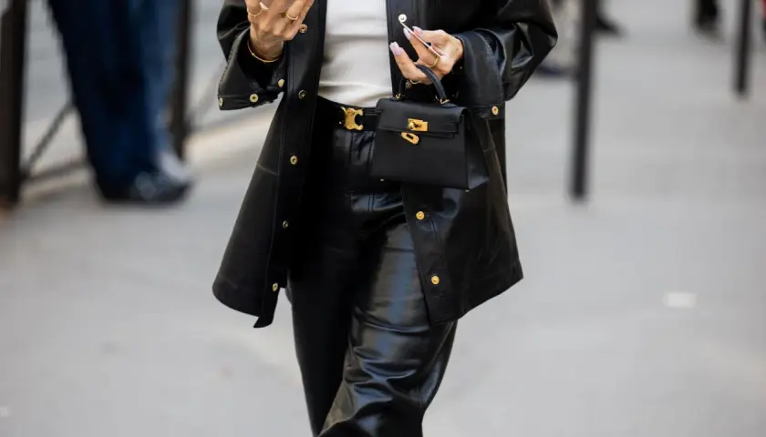 Schwarze Lederhose mit passendem Blazer und kleiner Handtasche. Die Frage "welche schuhe zur schwarzen hose damen" wird hier stilvoll beantwortet: schlichte, elegante Schuhe.
