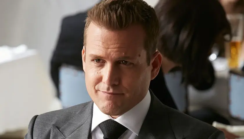 Harvey Specter im eleganten grauen Anzug, bereit für den nächsten Fall.