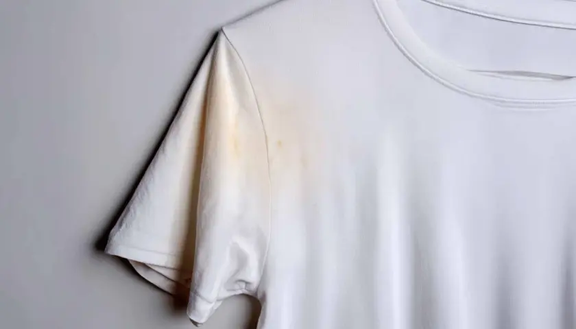 Weiße T-Shirt mit gelblichen, unbekannten Flecken nach dem Waschen unter dem Arm.