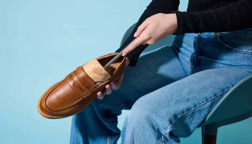 Braune Loafer werden mit einem Schuhspanner geweitet.