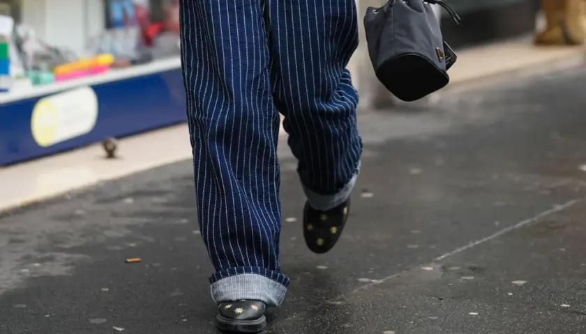 Moderne herren hosen mit umschlag, gestreift, mit Sternen-Schuhen und schwarzer Tasche.