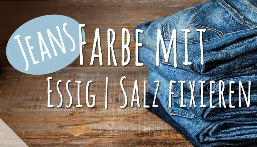 Neue Jeans Farbe mit Essig fixieren: Ein Stapel Jeans auf Holz.