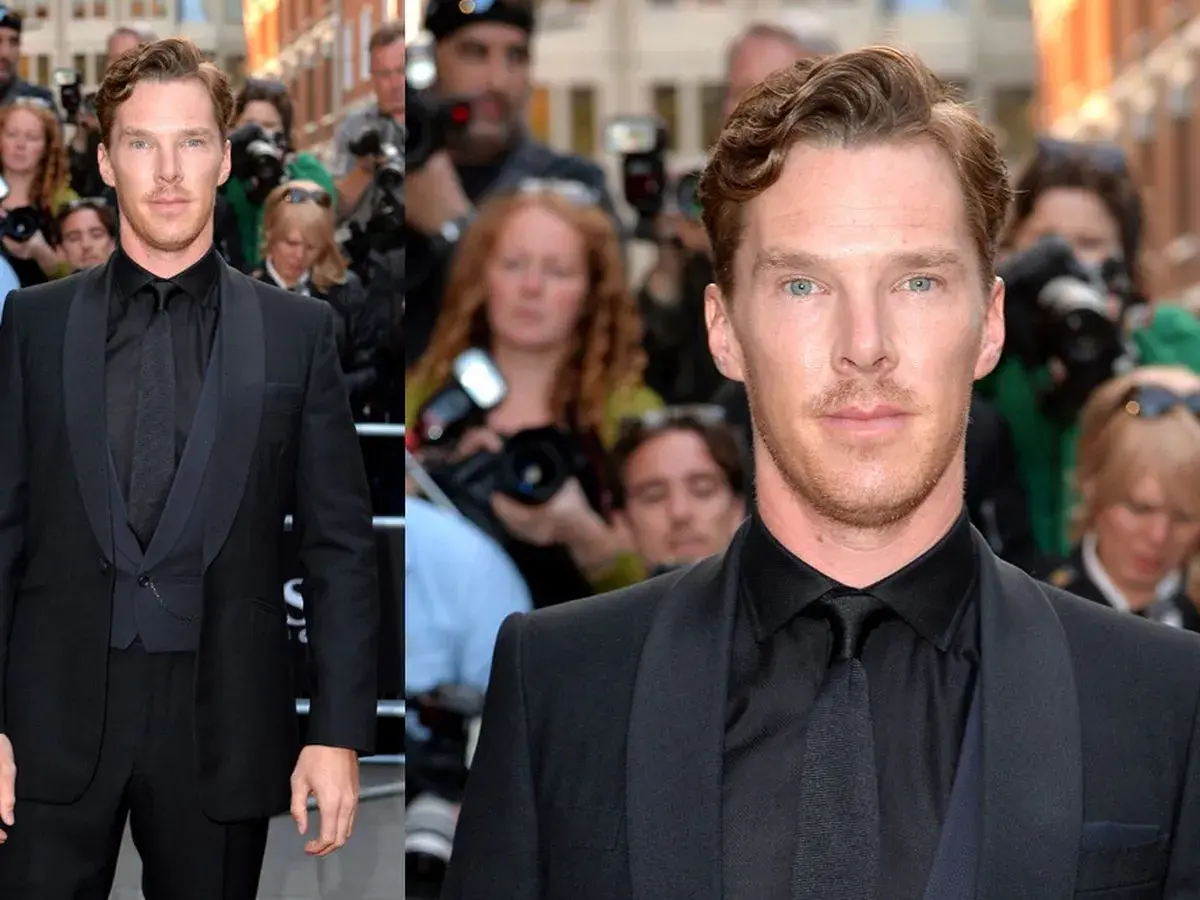 Benedict Cumberbatch im eleganten schwarzen Anzug und schwarzem Hemd, umgeben von Fotografen.