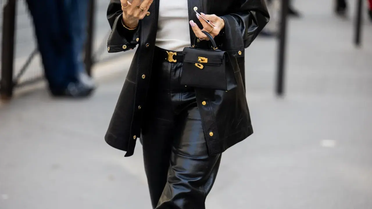 Schwarze Lederhose mit passendem Blazer und kleiner Handtasche. Die Frage "welche schuhe zur schwarzen hose damen" wird hier stilvoll beantwortet: schlichte, elegante Schuhe.