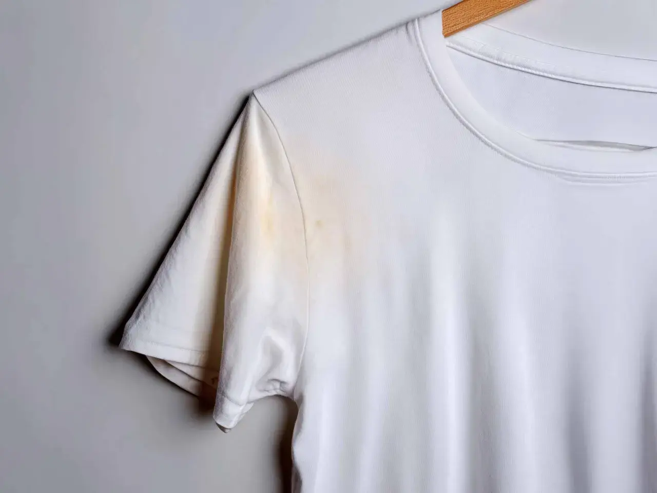 Weiße T-Shirt mit gelblichen, unbekannten Flecken nach dem Waschen unter dem Arm.
