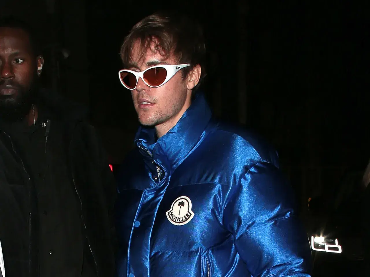 Mann mit auffälliger Moncler Jacke und Sonnenbrille, bereit für die Reinigung.