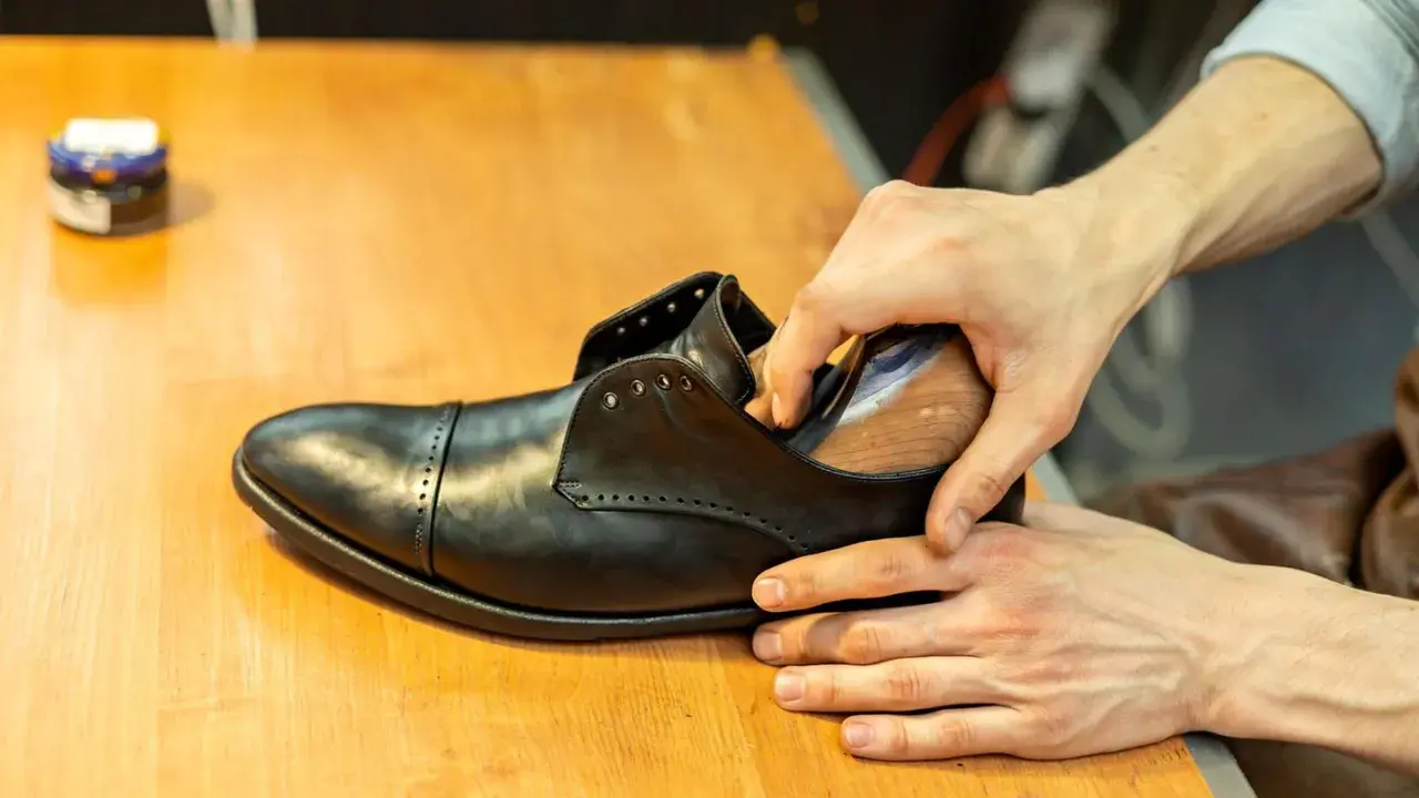 Schuhe weiten: Leder wird mit einem Leisten in Form gebracht, um den perfekten Sitz zu erzielen.