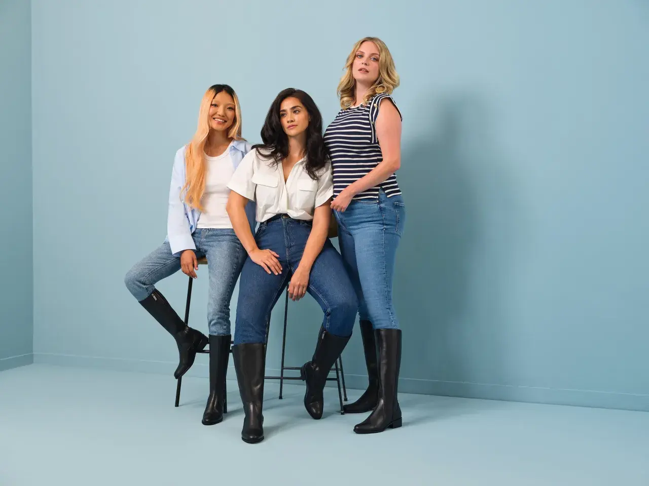 Drei Frauen zeigen, wie man lässige Jeans mit eleganten schwarzen Stiefeln kombiniert. Ein stylischer Look für jeden Tag.