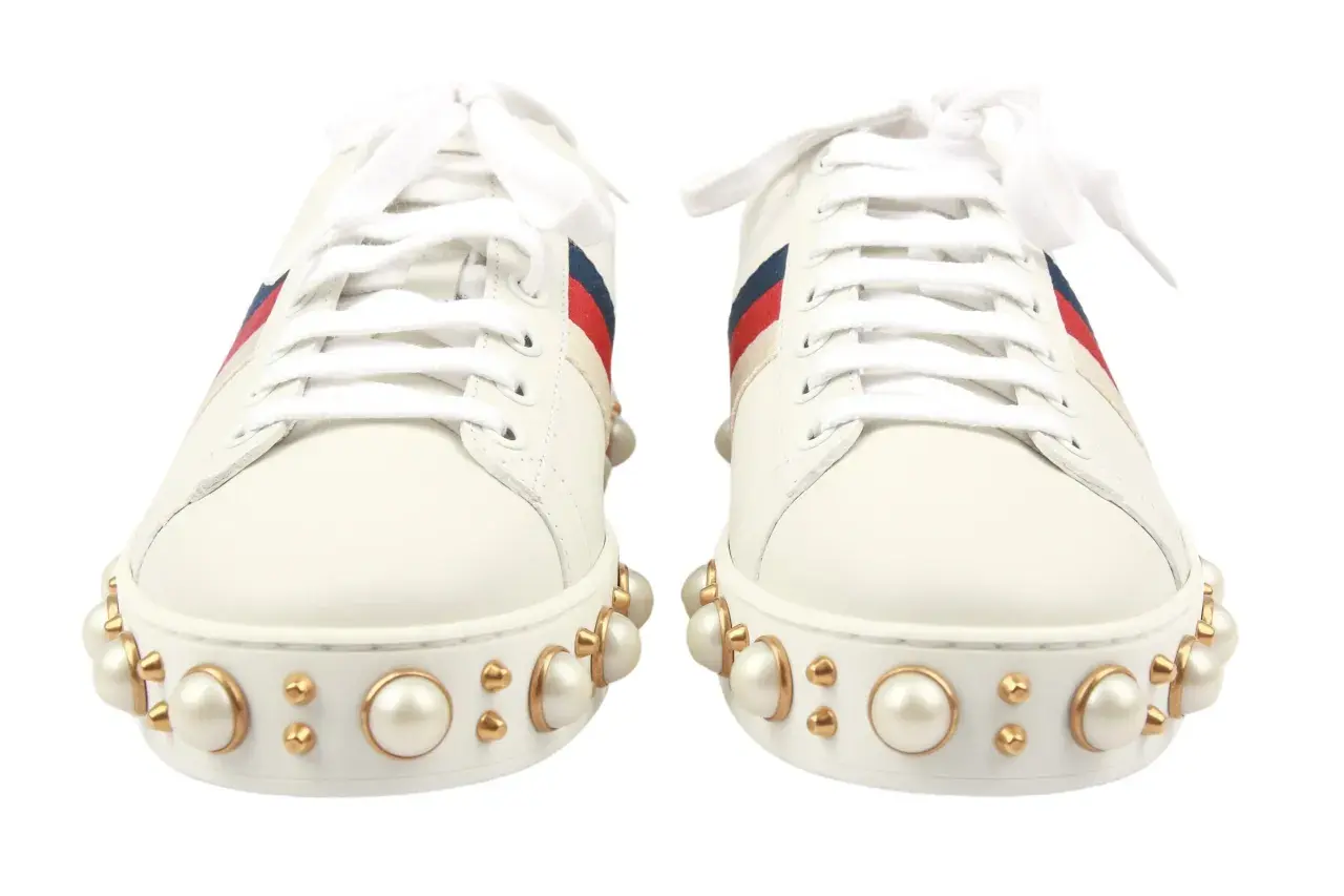 Weiße Gucci Sneaker mit Perlenbesatz und roten/blauen Streifen. Sie fallen größengerecht aus, perfekt für einen luxuriösen Look.