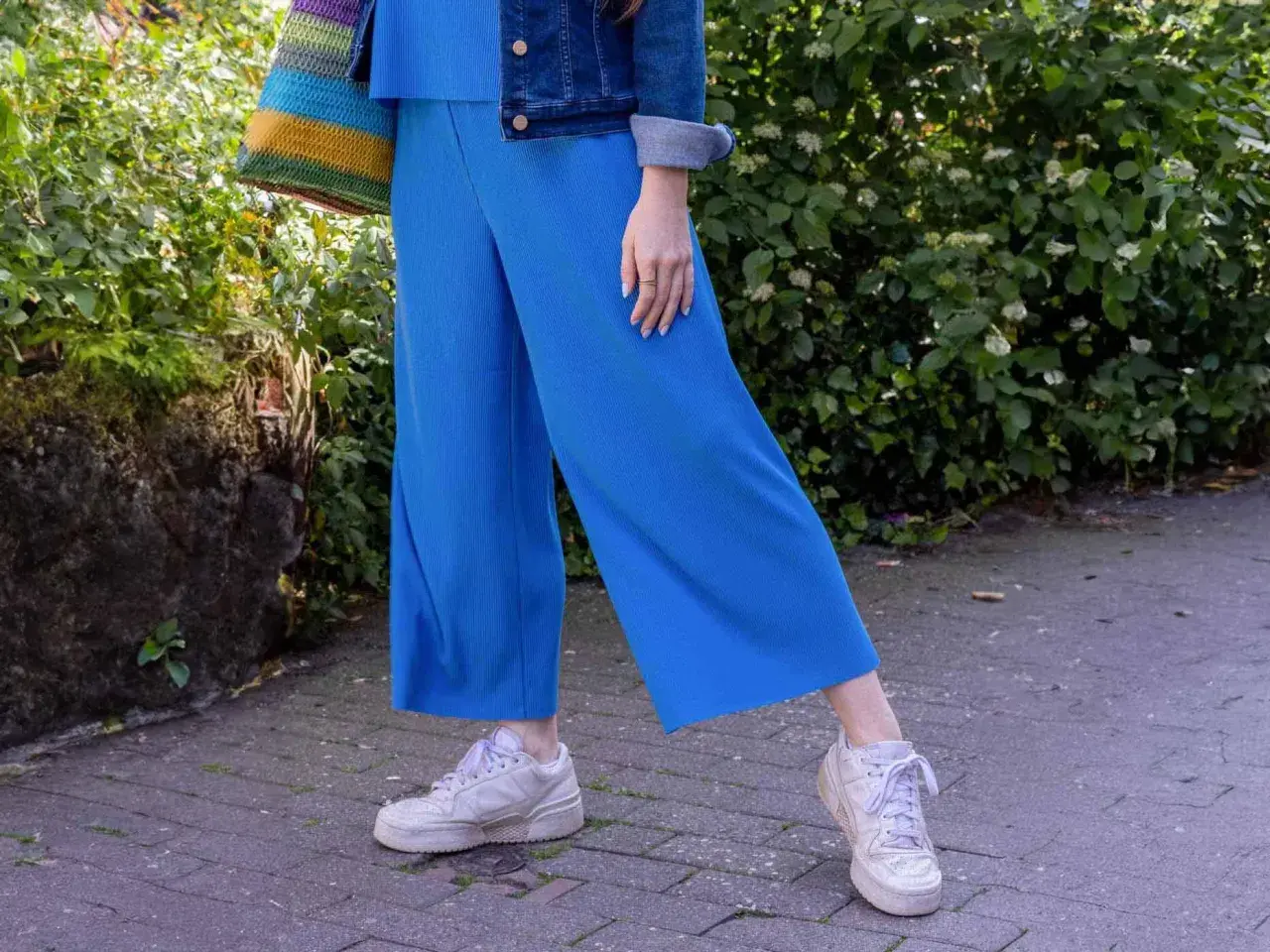 Blaues Culotte-Outfit mit Jeansjacke und bunten Tasche. So lässt sich die Culotte lässig kombinieren.