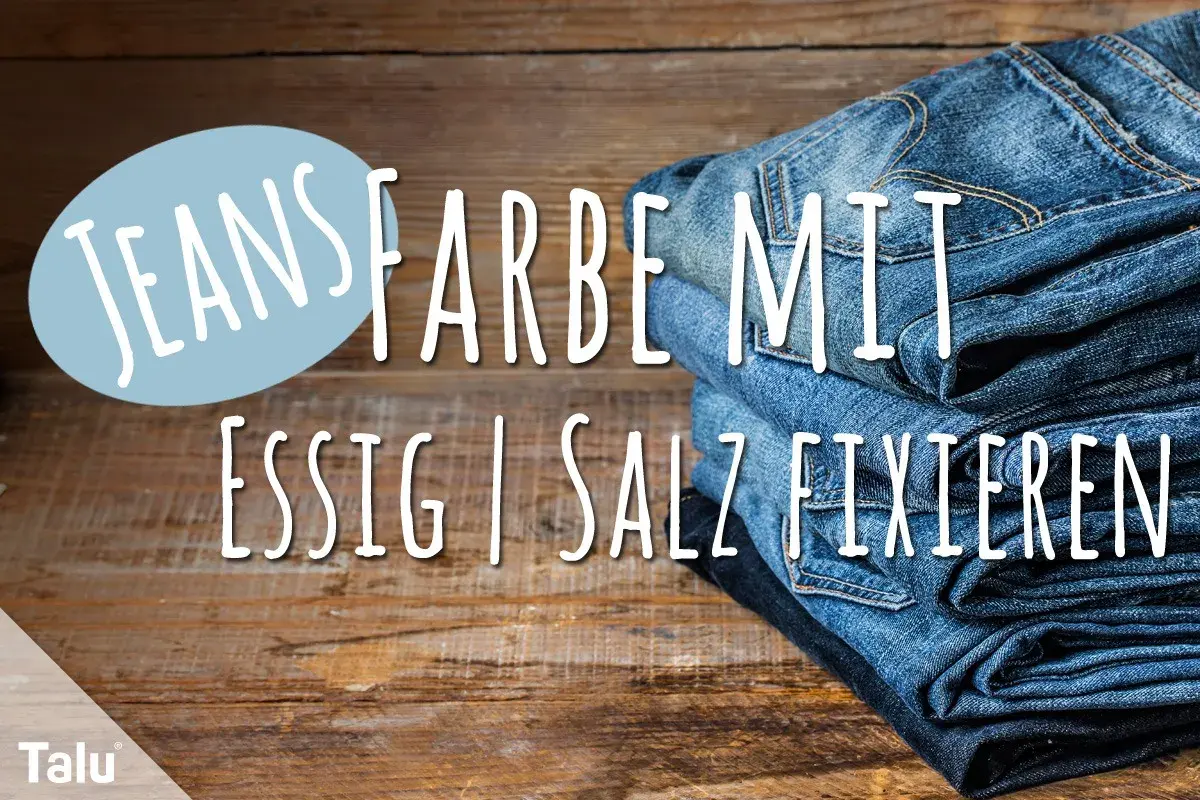 Neue Jeans Farbe mit Essig fixieren: Ein Stapel Jeans auf Holz.