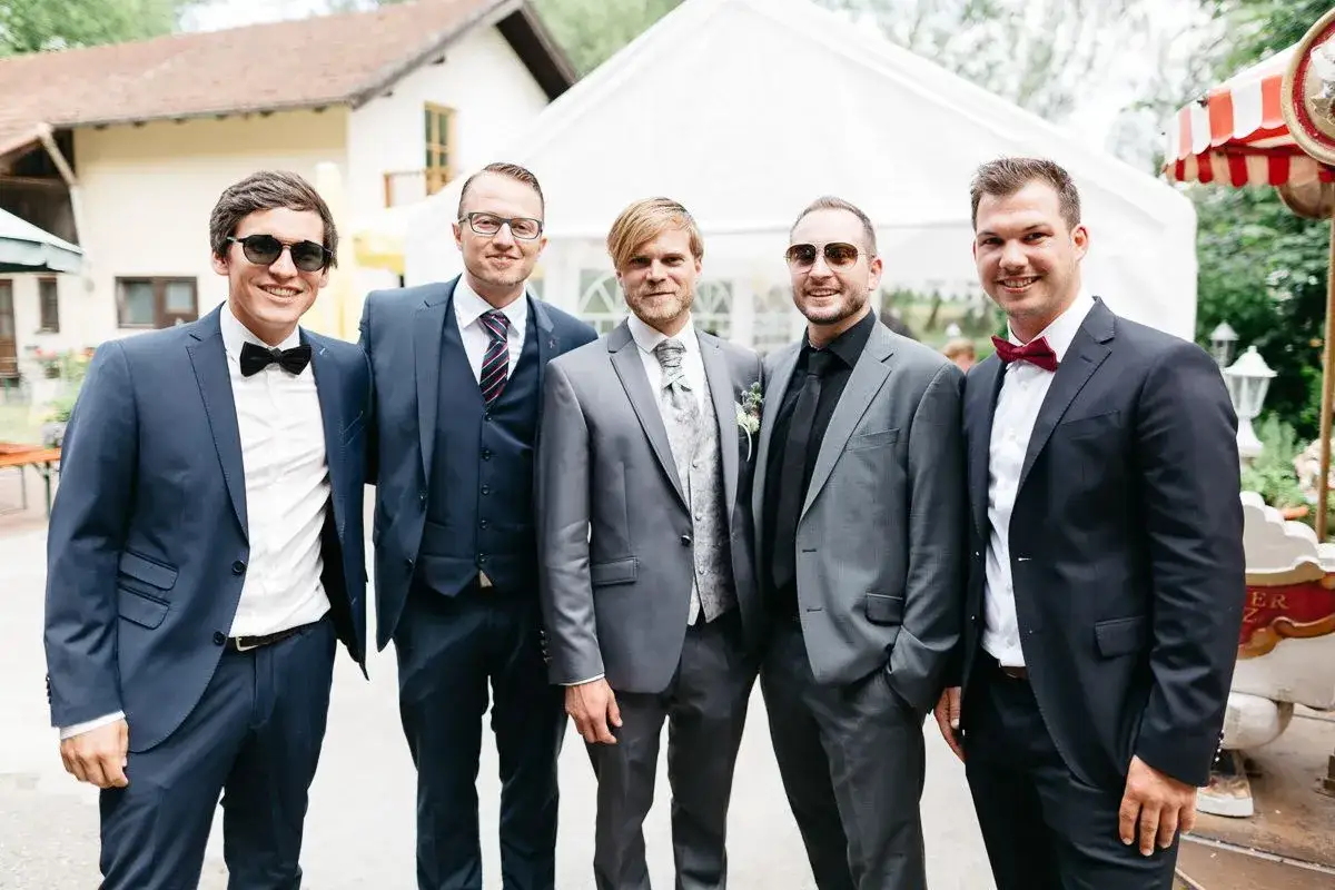 Fünf Männer in Anzügen, bereit als Trauzeugen beim Standesamt.
