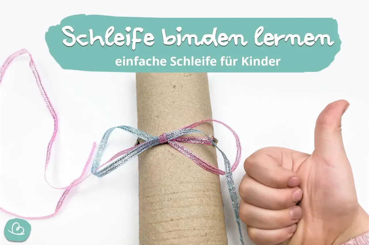 Daumen hoch f&uuml;r das Erlernen einer einfachen Schleife, wie sie auch f&uuml;r ein Kinder-Dirndl n&uuml;tzlich ist. Glitzerband in Rosa und Blau wird um eine Papprolle gebunden.