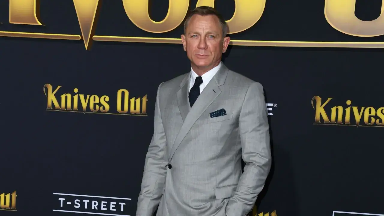 Daniel Craig im eleganten grauen Anzug mit blau-weiß gepunktetem Einstecktuch.