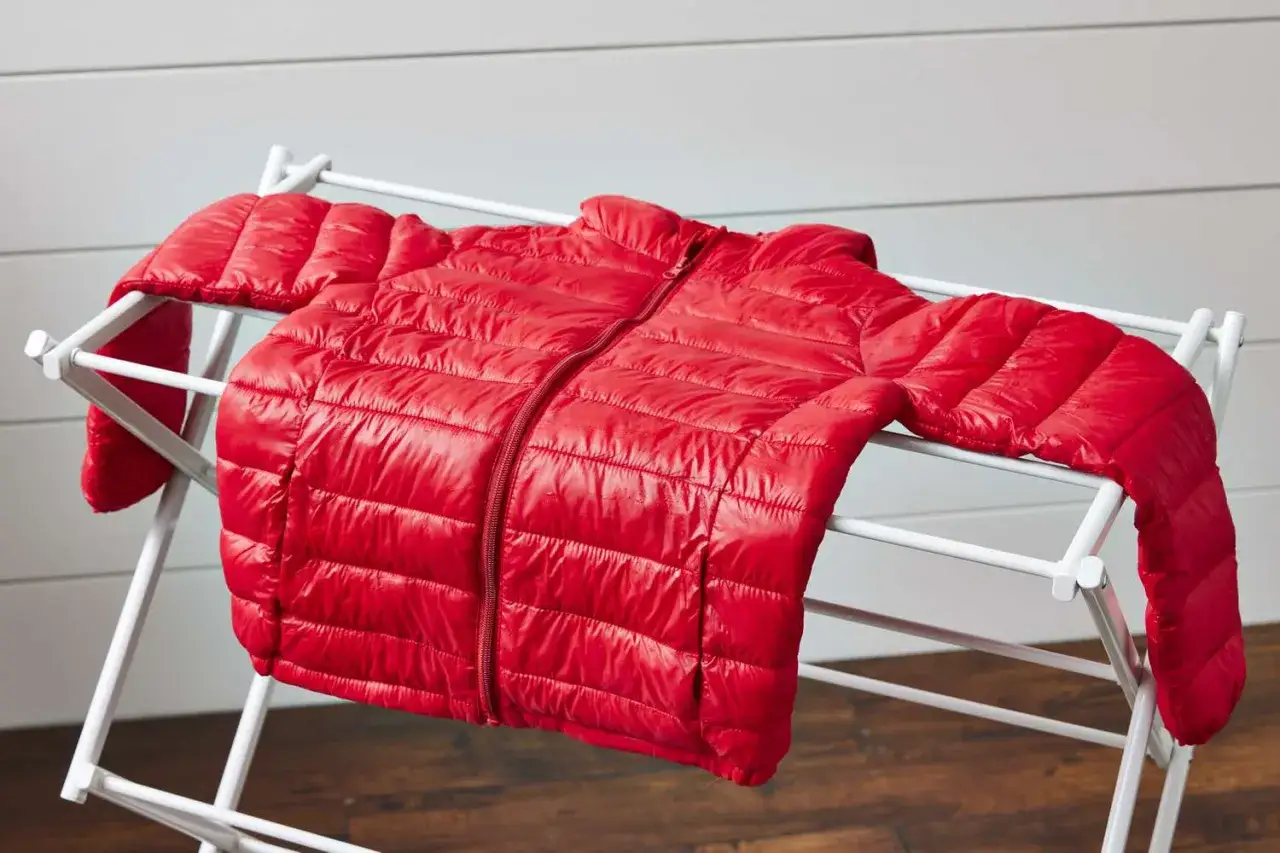 Rote Daunenjacke trocknen auf einem W&auml;schest&auml;nder.