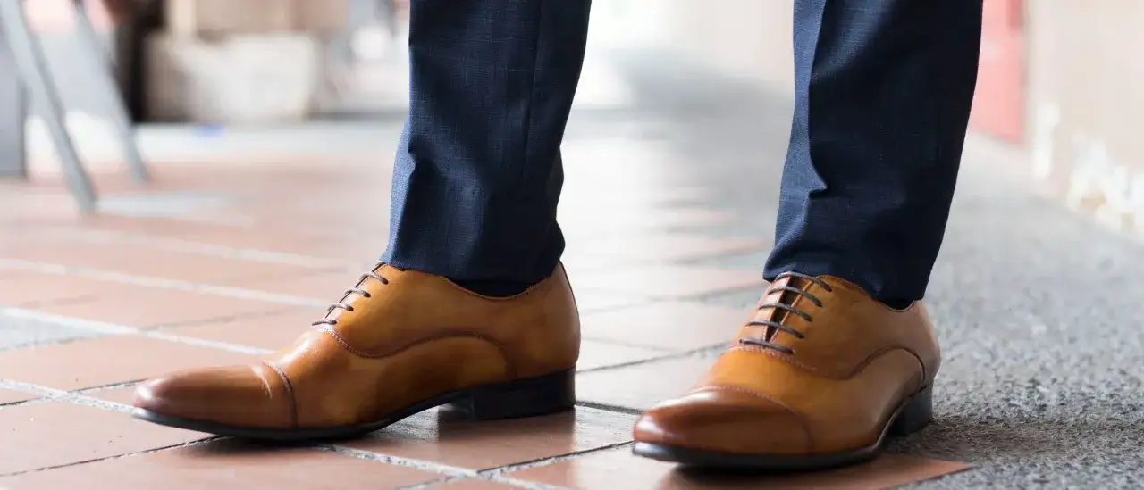 Elegante braune Schuhe kombinieren perfekt mit einer dunkelblauen Anzughose f&uuml;r einen stilvollen Look.